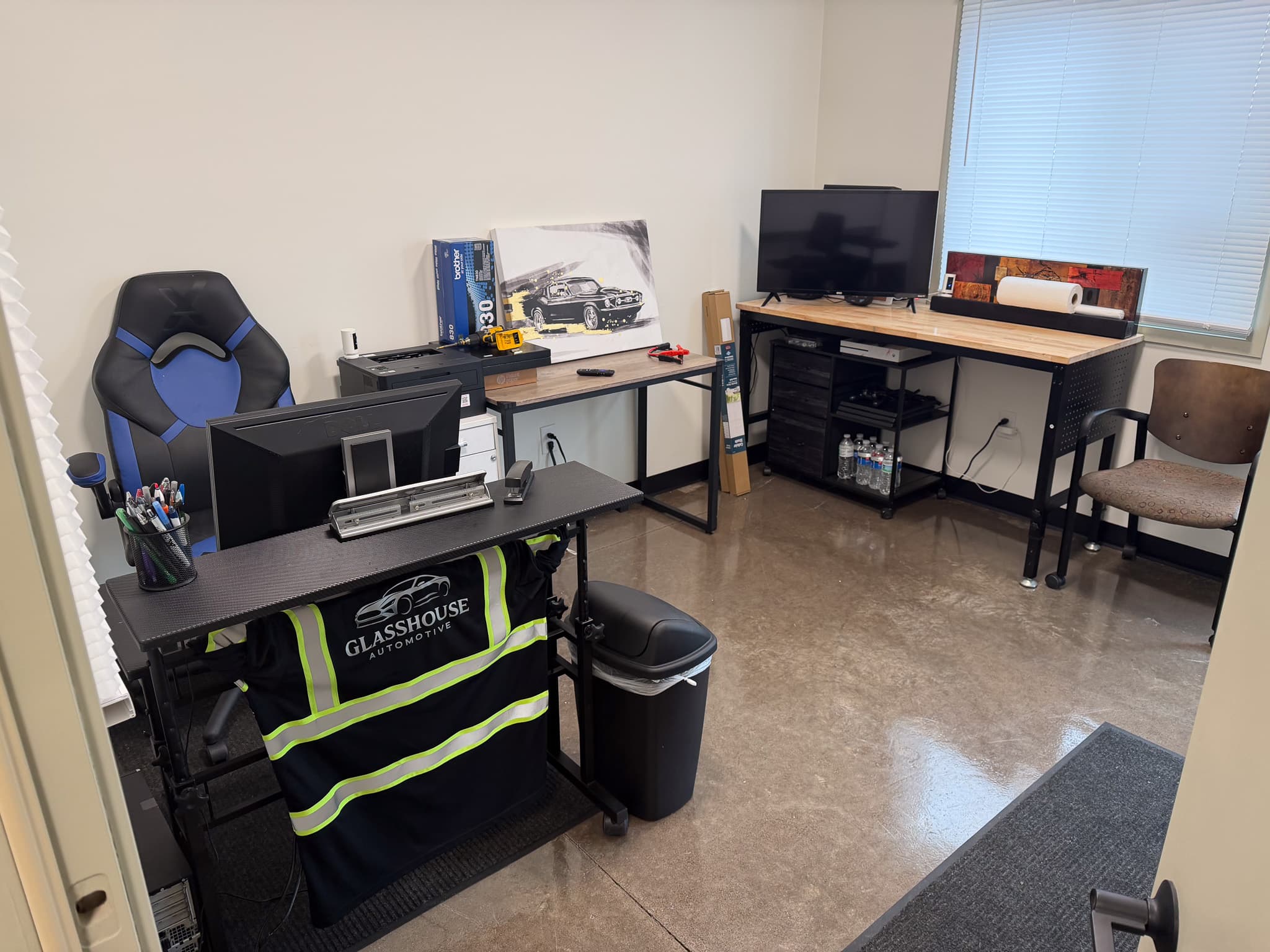 Sales desk at Glasshouse Automotive with the dealership vest, workstation, and printer