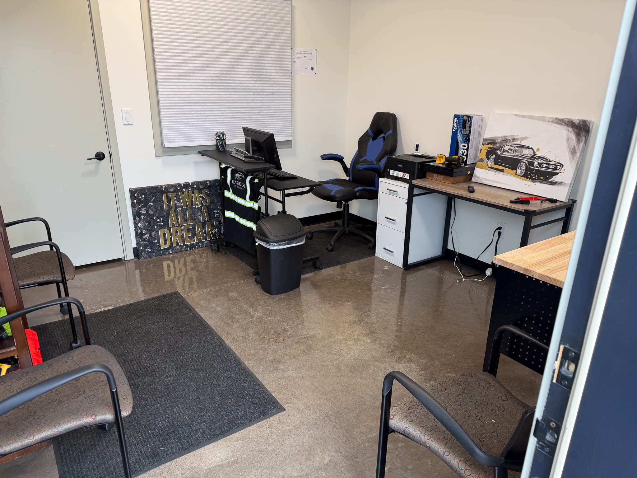 Glasshouse Automotive office with customer seating, the sales desk, and vehicle artwork